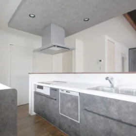 下がり天井のアクセントクロスと雰囲気の合う、ロッシュチャコールのキッチン