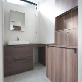 洗面脱衣室。上質感のある家具のようなデザインの洗面化粧台&ランドリーボックスがポイント。