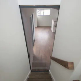 階段側からリビングを見下ろした様子。クリアグレーのガラス戸があることで、スタイリッシュに&匂いや空調効率などの機能性も◎